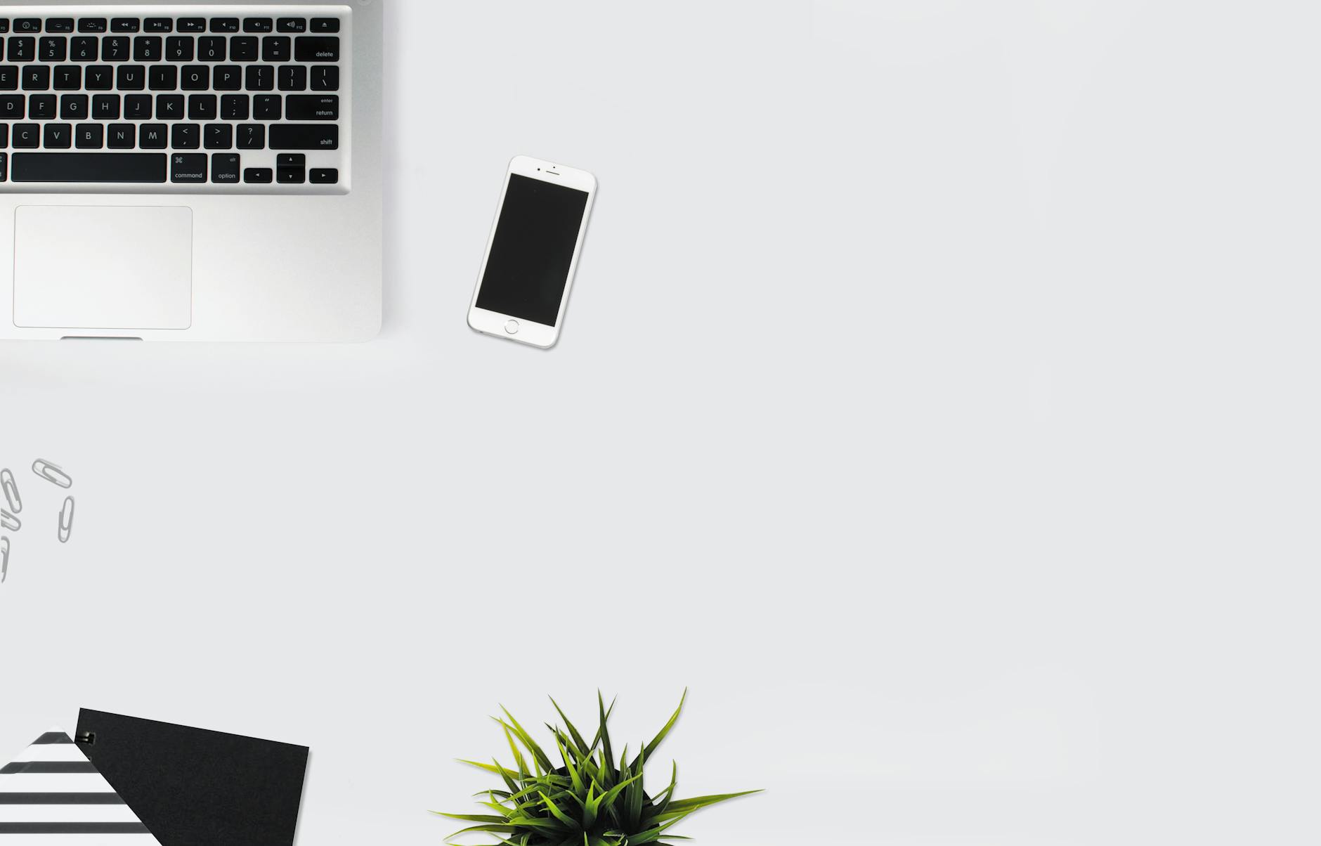 white smartphone beside silver laptop computer